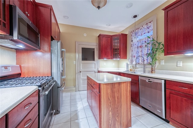 kitchen featuring a center island, hanging light fixtures, sink, appliances with stainless steel finishes, and light tile patterned flooring