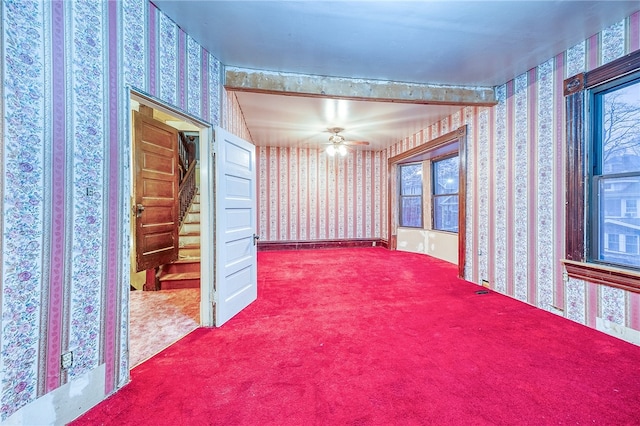 carpeted spare room featuring ceiling fan