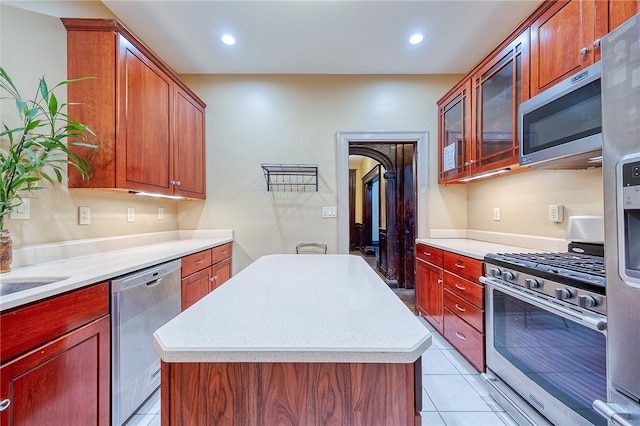 kitchen featuring light tile patterned floors, stainless steel appliances, and a kitchen island