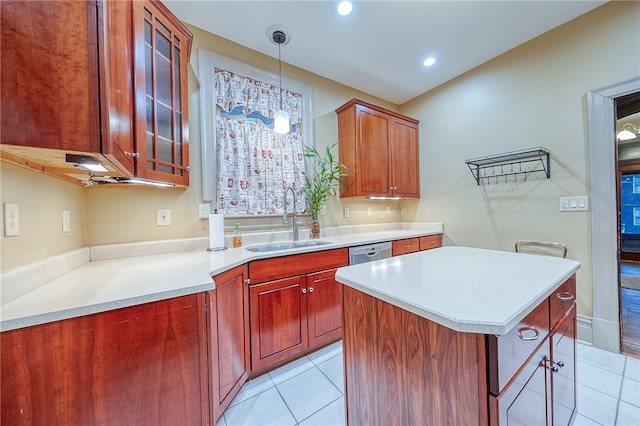 kitchen featuring pendant lighting, a center island, sink, light tile patterned floors, and a breakfast bar area