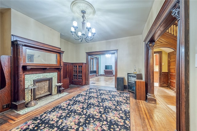 living room featuring wood walls, a fireplace, and a chandelier