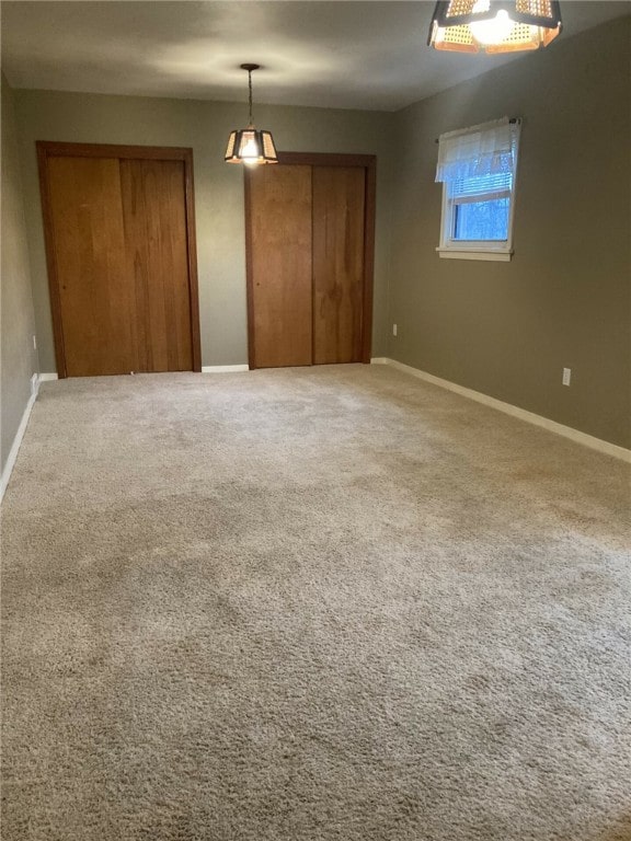 unfurnished bedroom featuring carpet floors and multiple closets