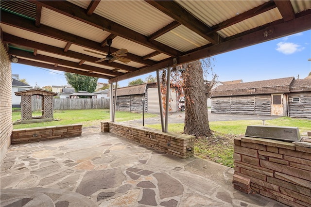 view of patio / terrace with ceiling fan and a shed