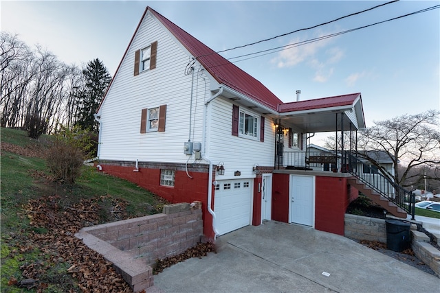 view of side of home featuring a porch and a garage