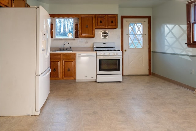 kitchen with white appliances, sink, and tasteful backsplash