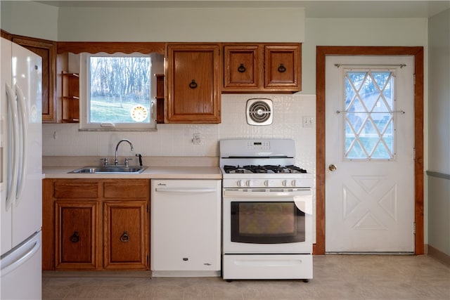 kitchen with backsplash, sink, and white appliances