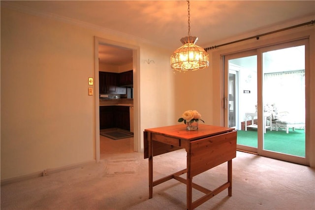 dining room featuring light carpet, crown molding, and an inviting chandelier