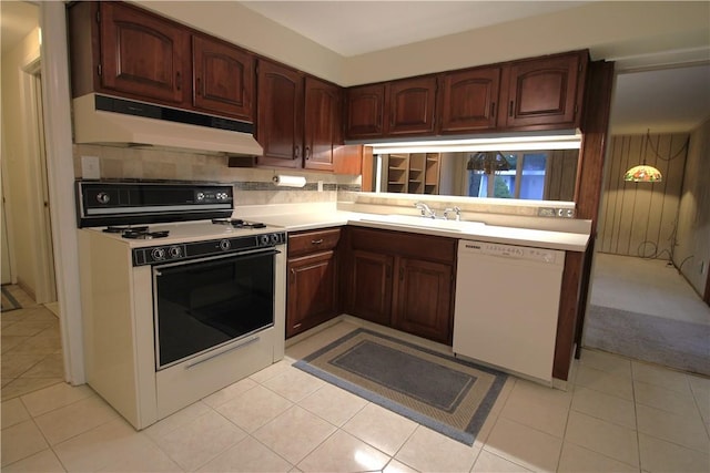 kitchen with tasteful backsplash, sink, light tile patterned flooring, and white appliances