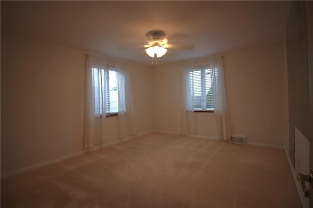 carpeted empty room with ceiling fan and a healthy amount of sunlight