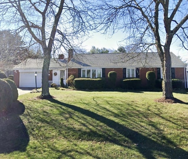 ranch-style house with an attached garage, a front lawn, and brick siding