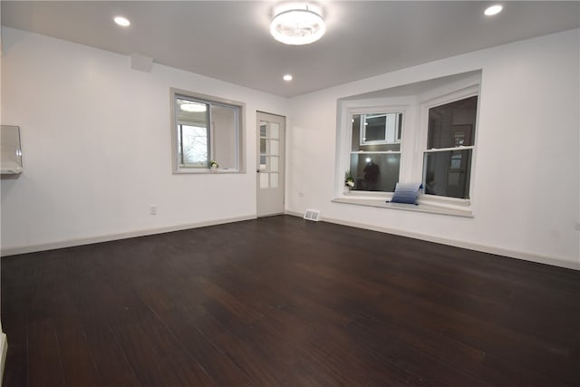 unfurnished room with dark wood-type flooring