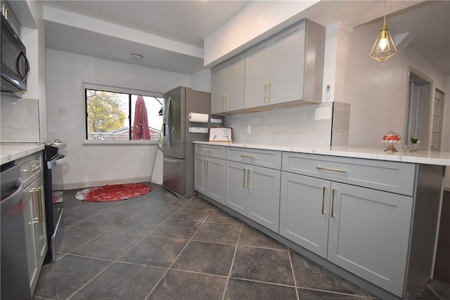 kitchen with gray cabinetry, pendant lighting, appliances with stainless steel finishes, and dark tile patterned flooring