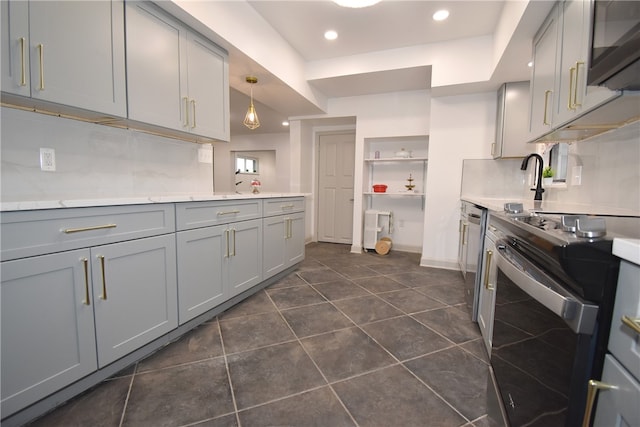 kitchen with backsplash, decorative light fixtures, gray cabinets, dark tile patterned flooring, and appliances with stainless steel finishes