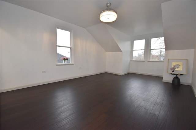 bonus room with dark hardwood / wood-style flooring, a healthy amount of sunlight, and vaulted ceiling