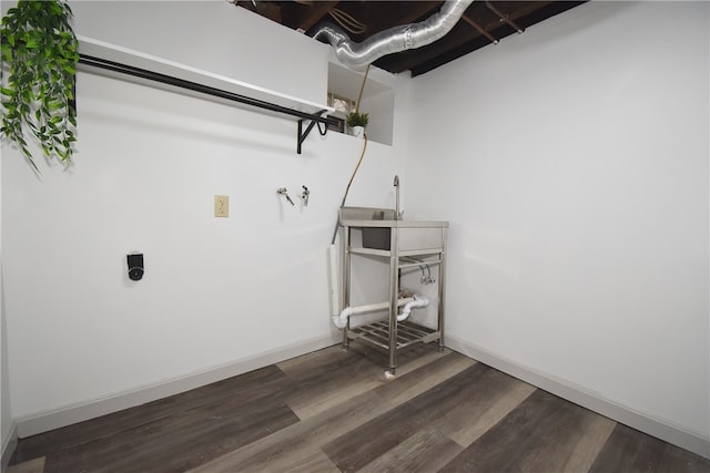 clothes washing area with hookup for an electric dryer and dark wood-type flooring