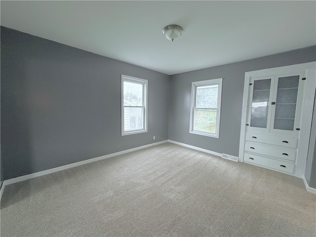 unfurnished bedroom featuring light carpet