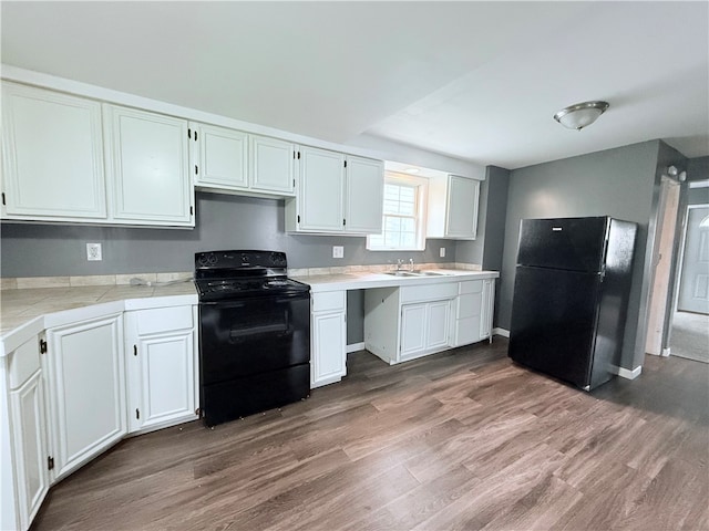 kitchen featuring black appliances, dark hardwood / wood-style flooring, white cabinetry, and sink