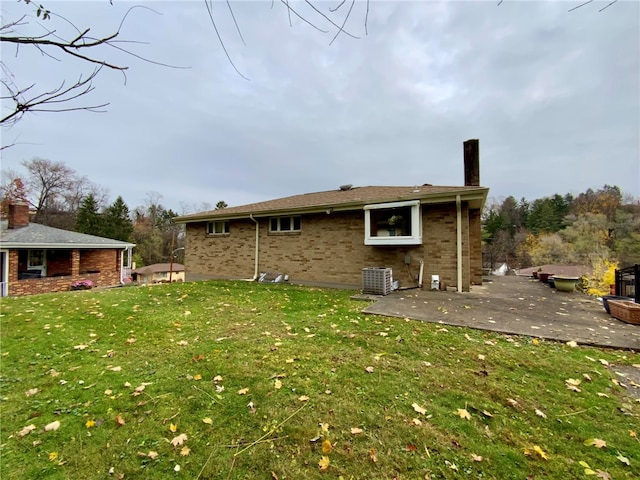 rear view of house with a yard, cooling unit, and a patio