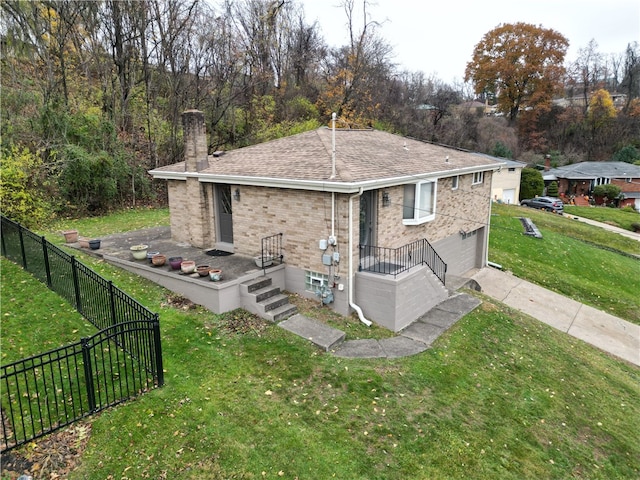 back of property featuring a garage and a lawn