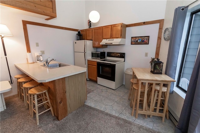 kitchen featuring white appliances, sink, light colored carpet, kitchen peninsula, and a breakfast bar area