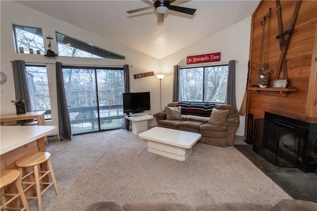 carpeted living room with ceiling fan, plenty of natural light, and vaulted ceiling