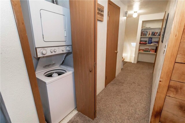 laundry area with light carpet and stacked washer and clothes dryer