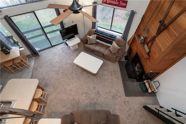 living room with ceiling fan, carpet, and a high ceiling