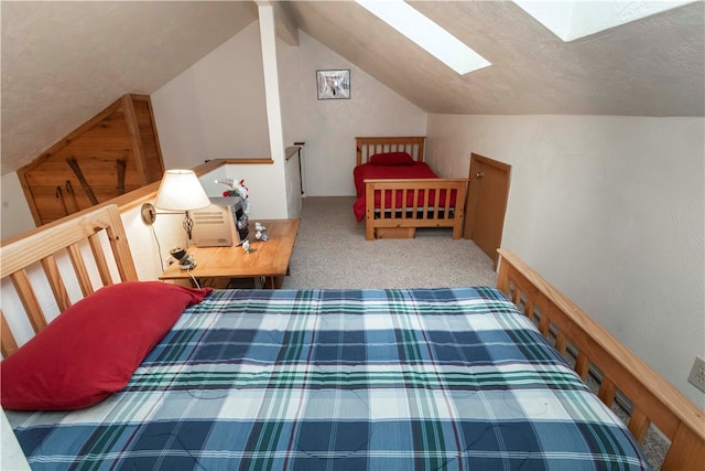 bedroom with vaulted ceiling with skylight, carpet floors, and a textured ceiling