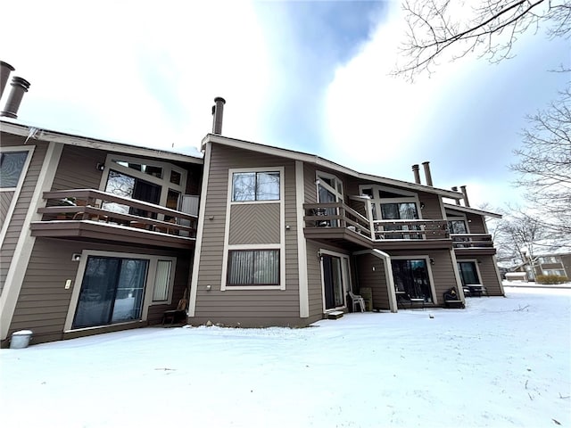 snow covered property featuring a balcony