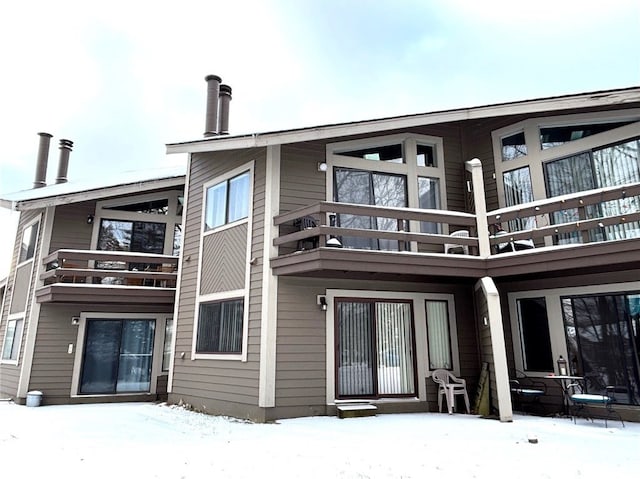 snow covered property featuring a balcony