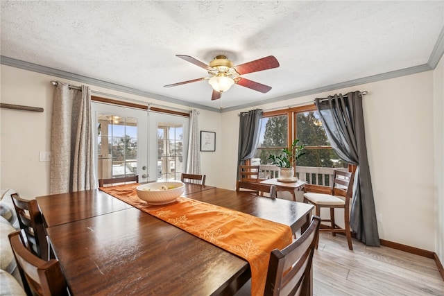 dining area with ceiling fan, french doors, light wood-type flooring, a textured ceiling, and ornamental molding