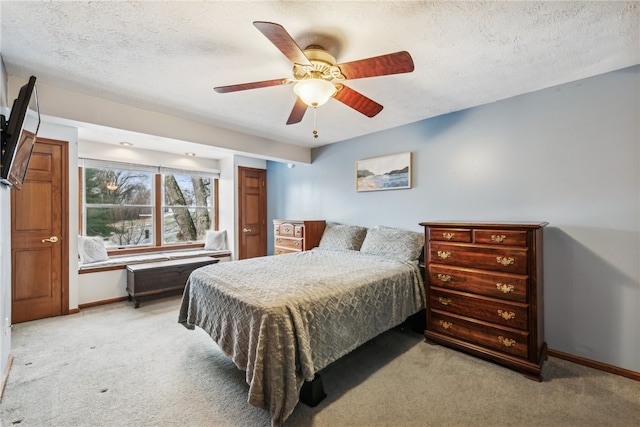 carpeted bedroom featuring a textured ceiling and ceiling fan