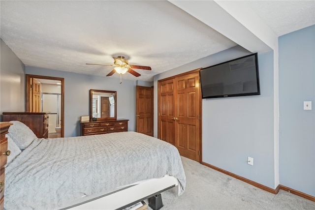 carpeted bedroom with ceiling fan, a closet, and a textured ceiling