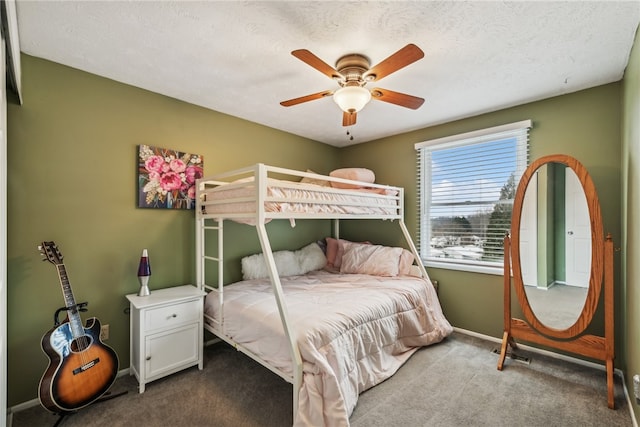 carpeted bedroom with ceiling fan and a textured ceiling