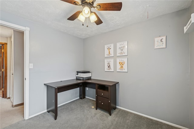 carpeted home office with a textured ceiling and ceiling fan