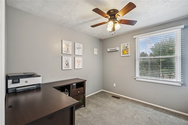 home office featuring light carpet, ceiling fan, and a textured ceiling