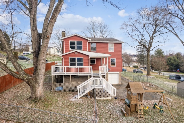 view of front of property featuring a garage, a playground, and a wooden deck