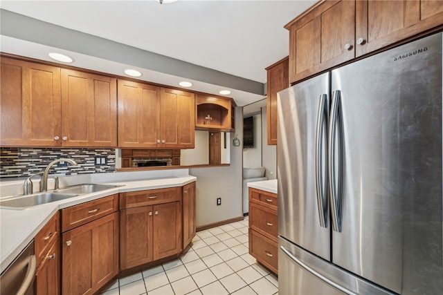 kitchen with tasteful backsplash, sink, light tile patterned flooring, and appliances with stainless steel finishes