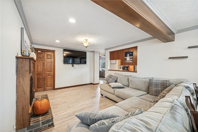 living room with ornamental molding, a textured ceiling, and light hardwood / wood-style flooring