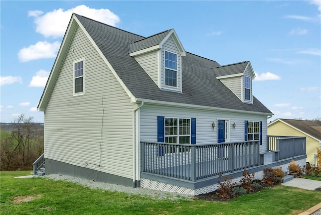 cape cod-style house with a front yard and a deck