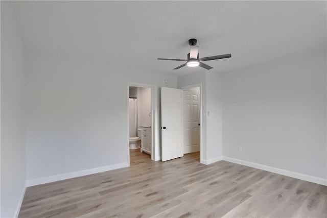 unfurnished bedroom featuring ceiling fan, light wood-type flooring, and ensuite bath