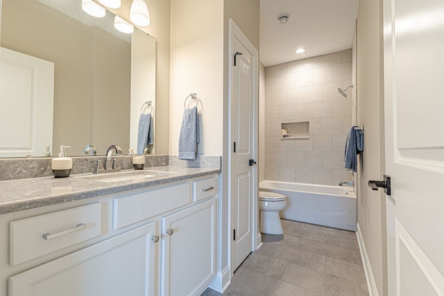 full bathroom featuring tile patterned flooring, vanity, tiled shower / bath combo, and toilet