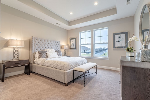 carpeted bedroom with a tray ceiling