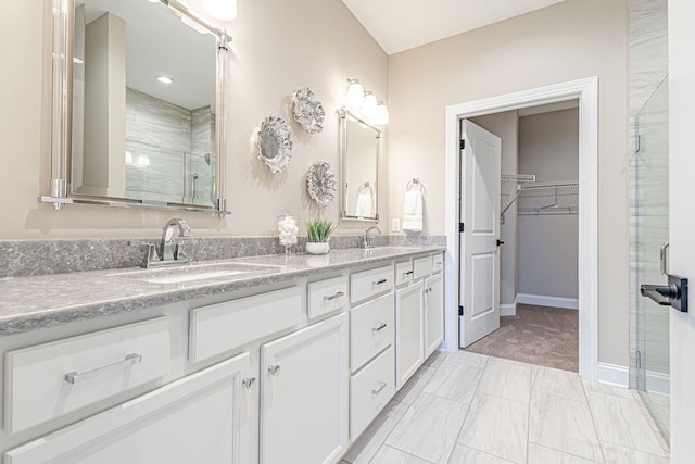 bathroom with vanity and a shower with door