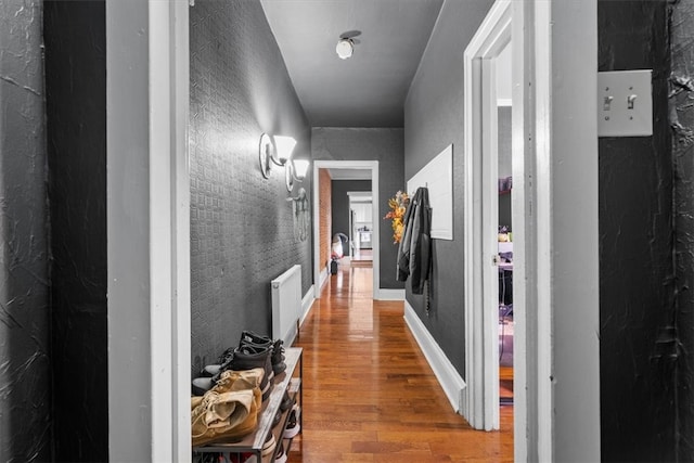 hallway featuring hardwood / wood-style floors and radiator heating unit