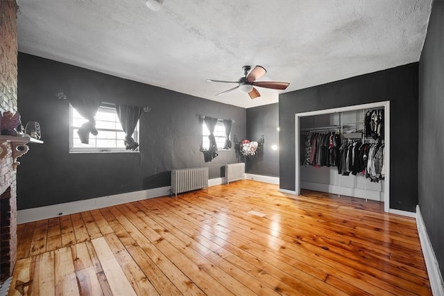 unfurnished bedroom with a closet, radiator heating unit, a textured ceiling, and hardwood / wood-style flooring