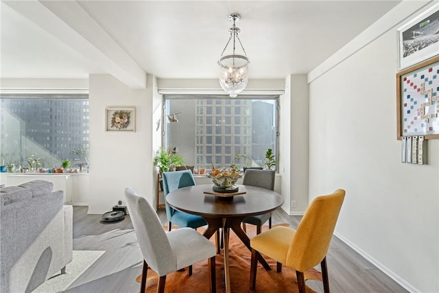 dining room with hardwood / wood-style floors and an inviting chandelier