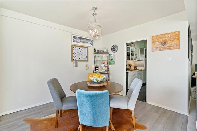 dining area featuring hardwood / wood-style flooring and an inviting chandelier