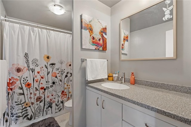 bathroom featuring a shower with curtain, vanity, and toilet