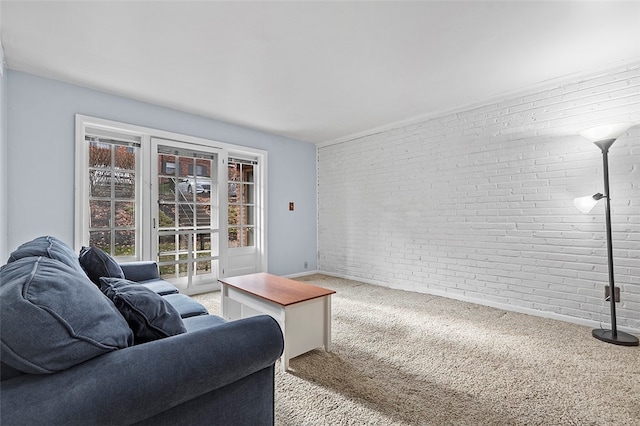 carpeted living room featuring brick wall